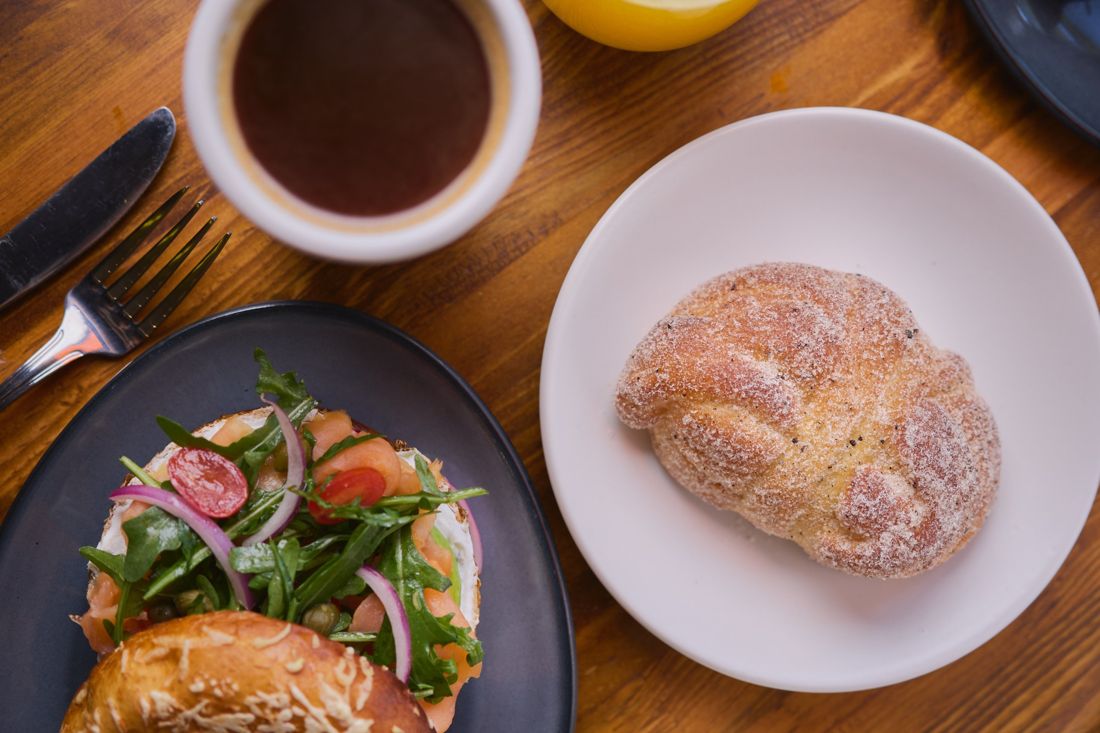 Desayuno con bagel de salmón, café y pan de azúcar